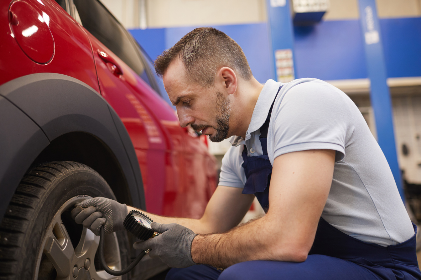 Mechanic Checking Pressure in Tires