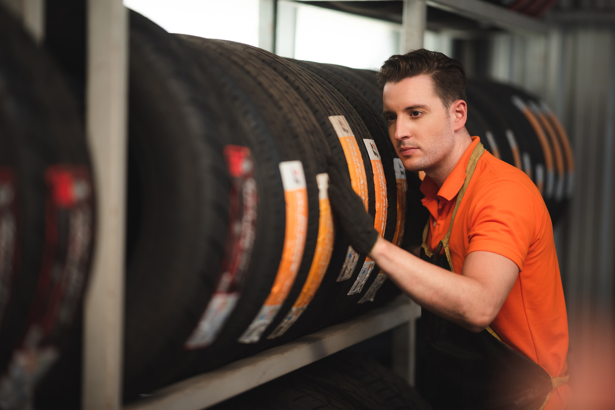 Young Car Mechanic Checking on Tires 